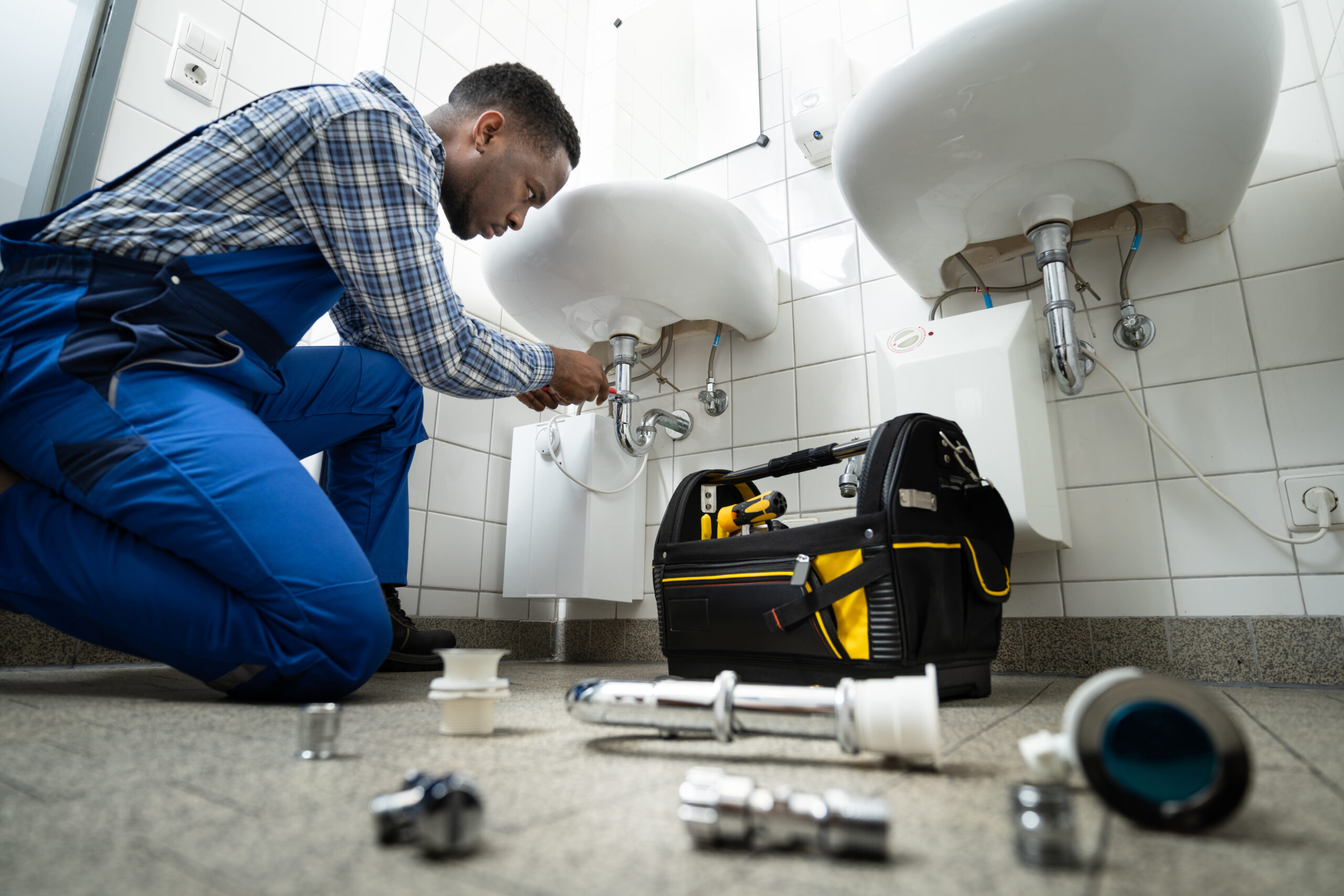 plumber working under sinks denten insurance